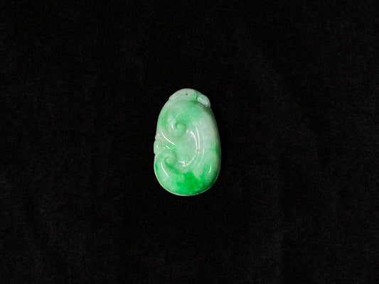 A milky white jadeite loose stone with floating apple green patterns, carved into a Ruyi symbol.