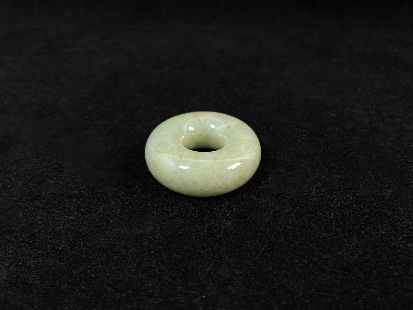 A light green jade donut-shaped stone with golden accents.