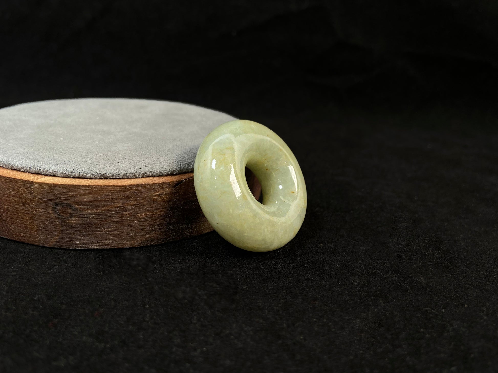 A light green jade donut-shaped stone with golden accents.