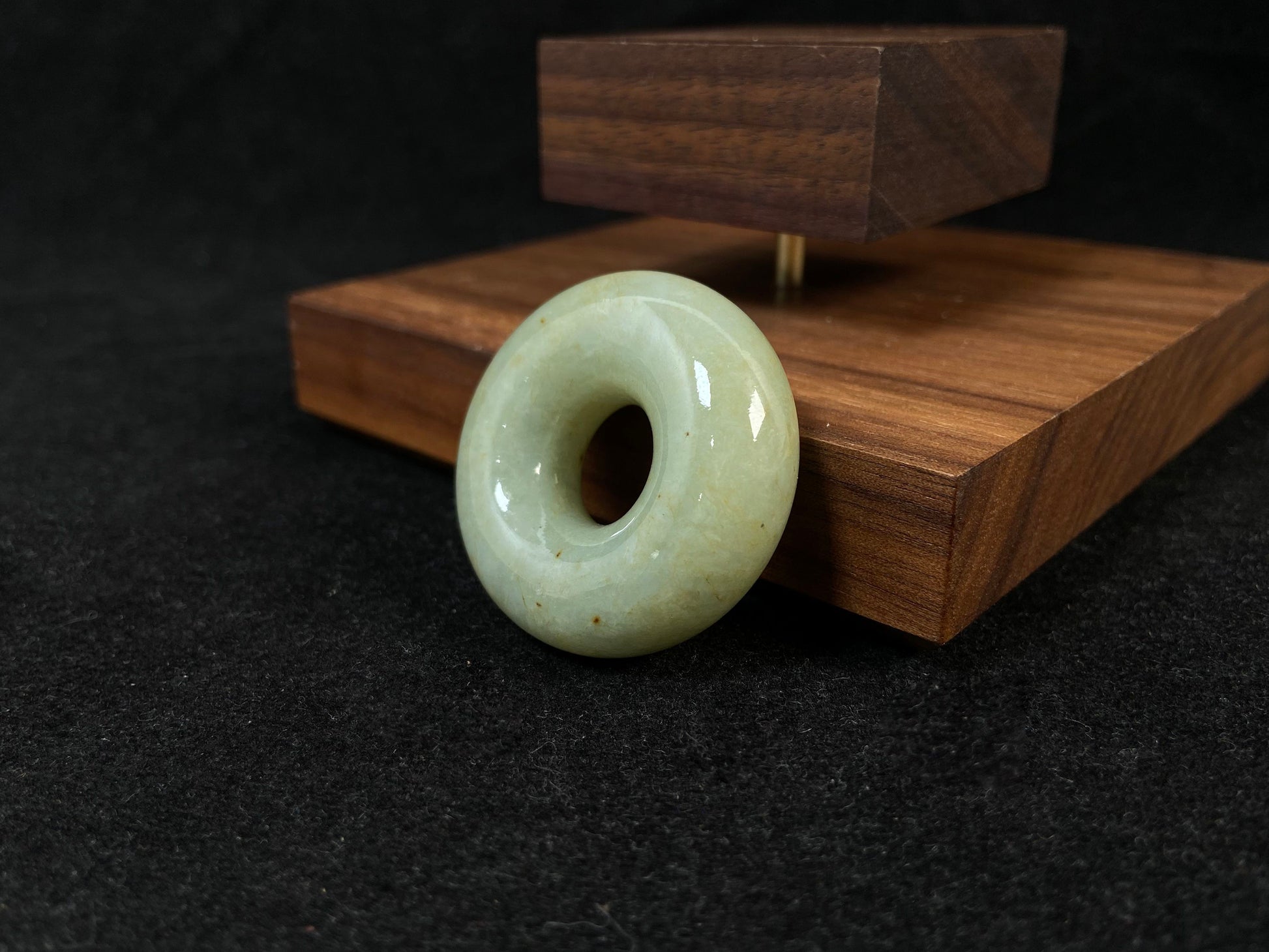 A light green jade donut-shaped stone with golden accents.