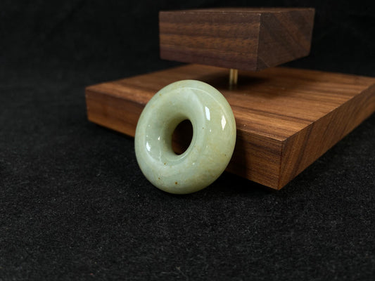 A light green jade donut-shaped stone with golden accents.