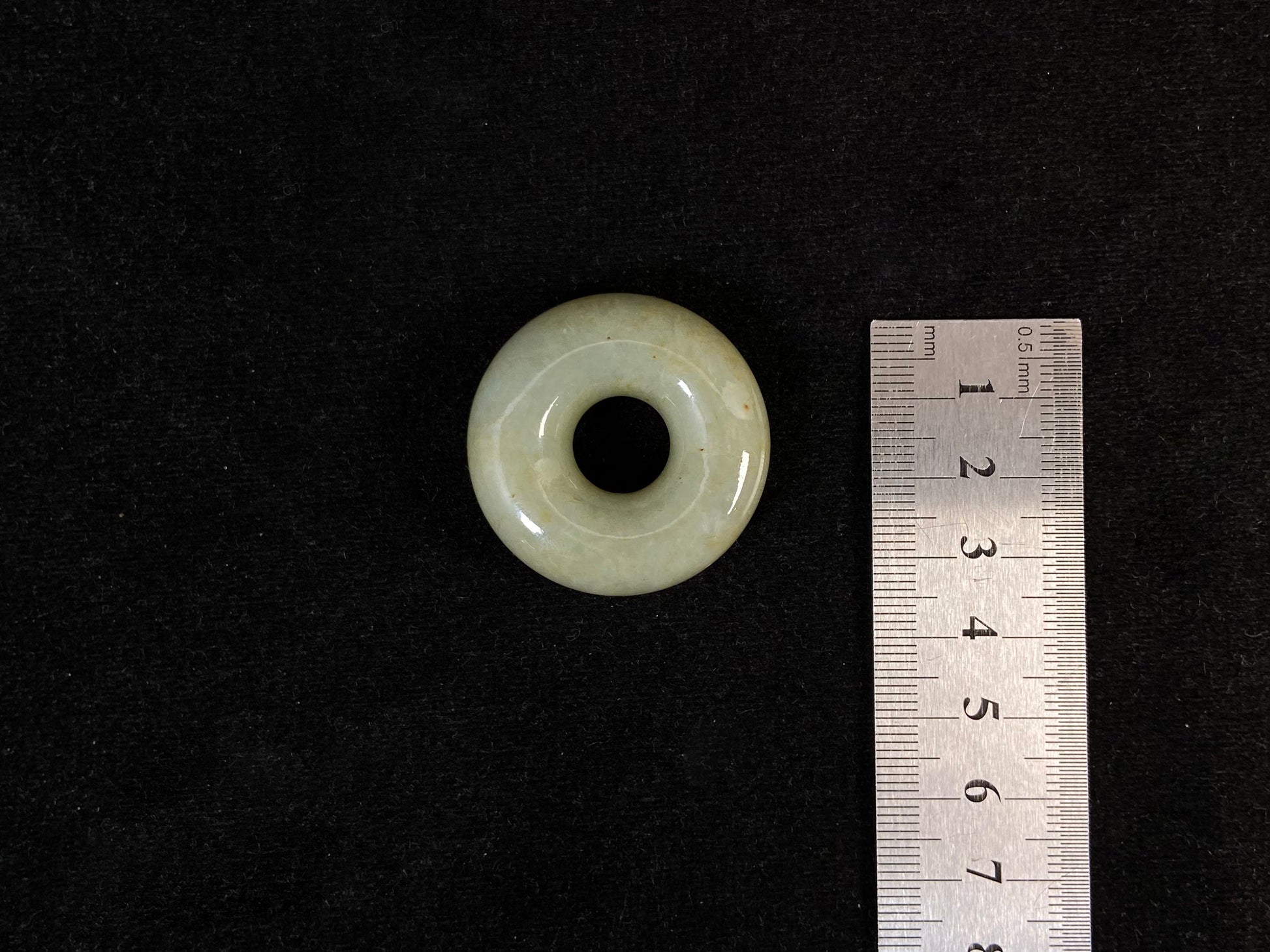 A light green jade donut-shaped stone with golden accents.