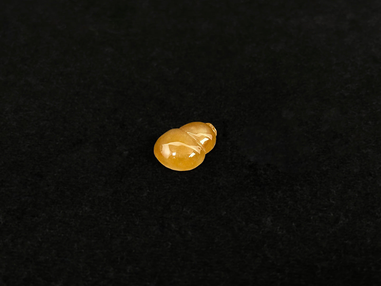 An amber jade stone featuring a calabash motif.