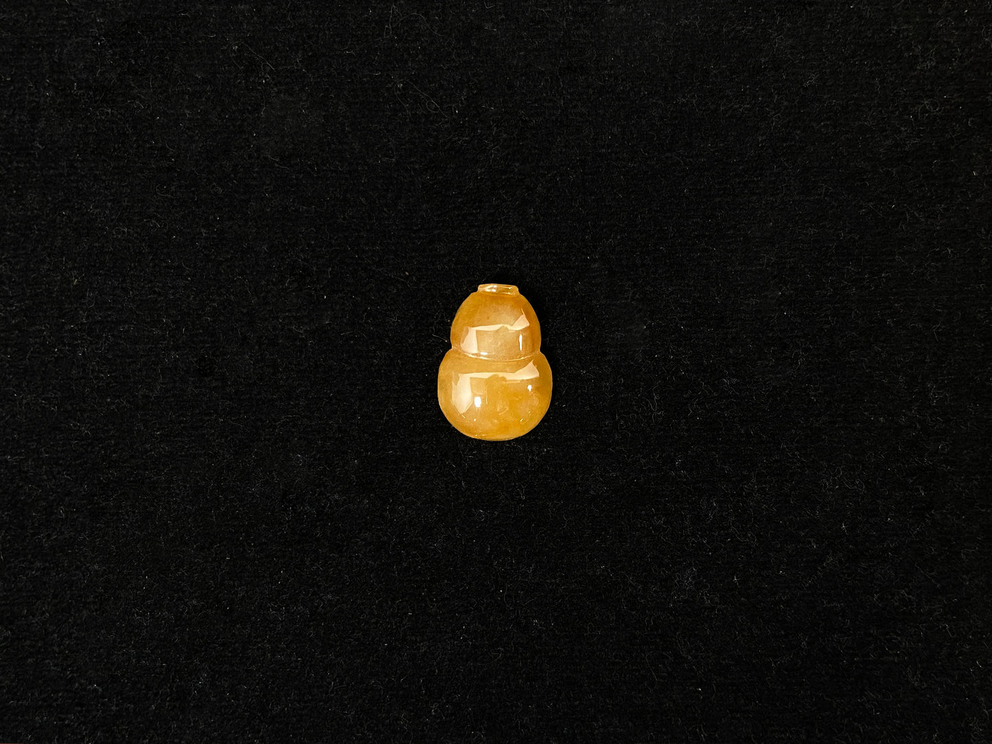 An amber jade stone featuring a calabash motif.