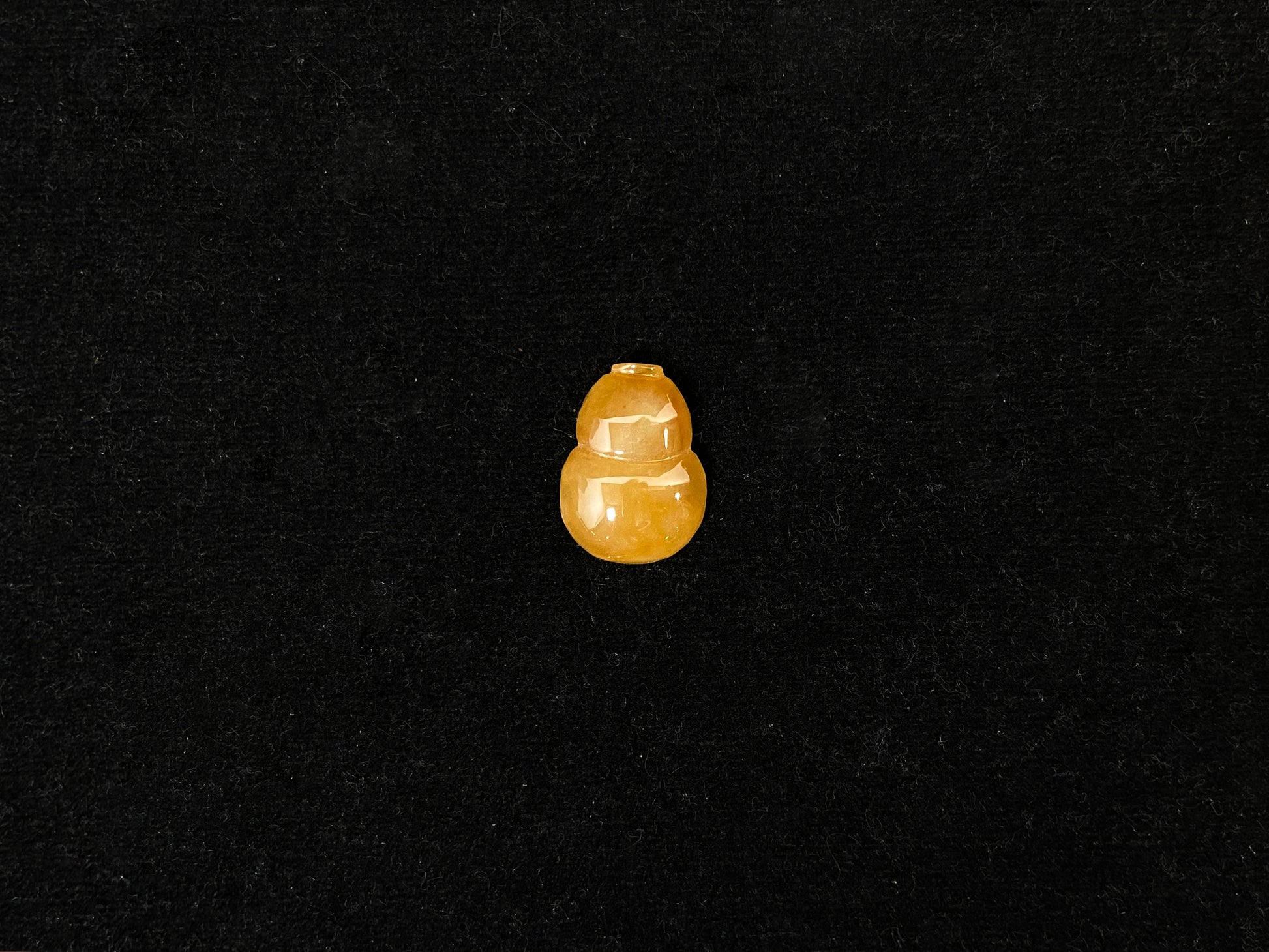 An amber jade stone featuring a calabash motif.