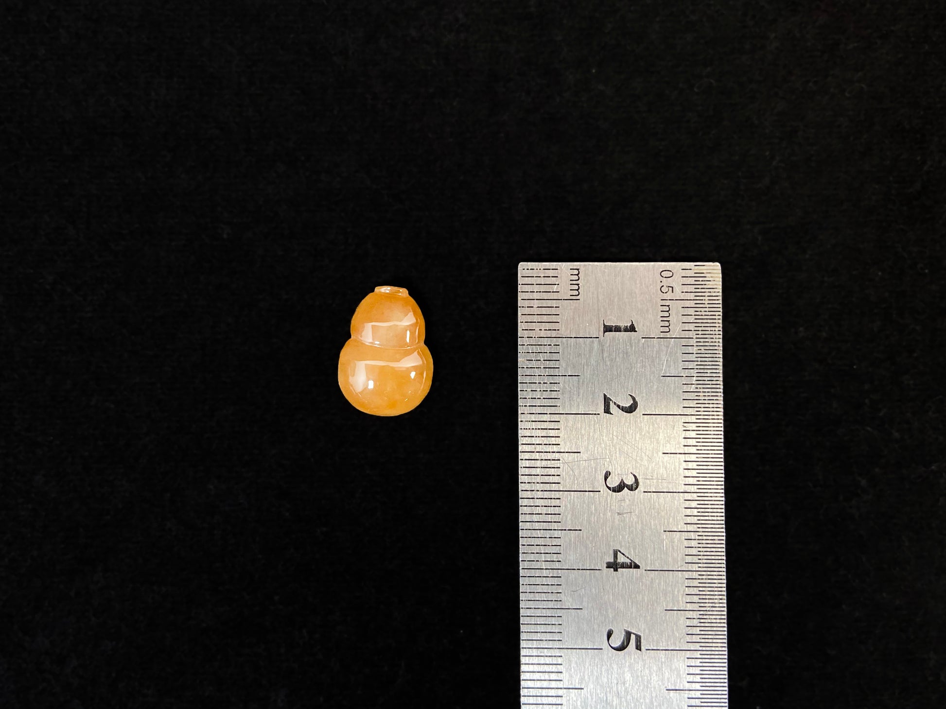 An amber jade stone featuring a calabash motif.
