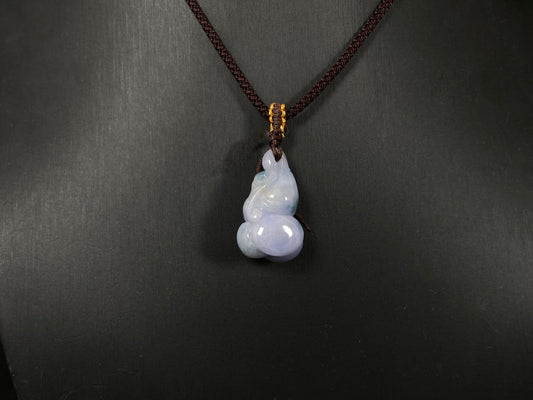 A violet jade carving of three entwined gourds, kissed by wisps of green.