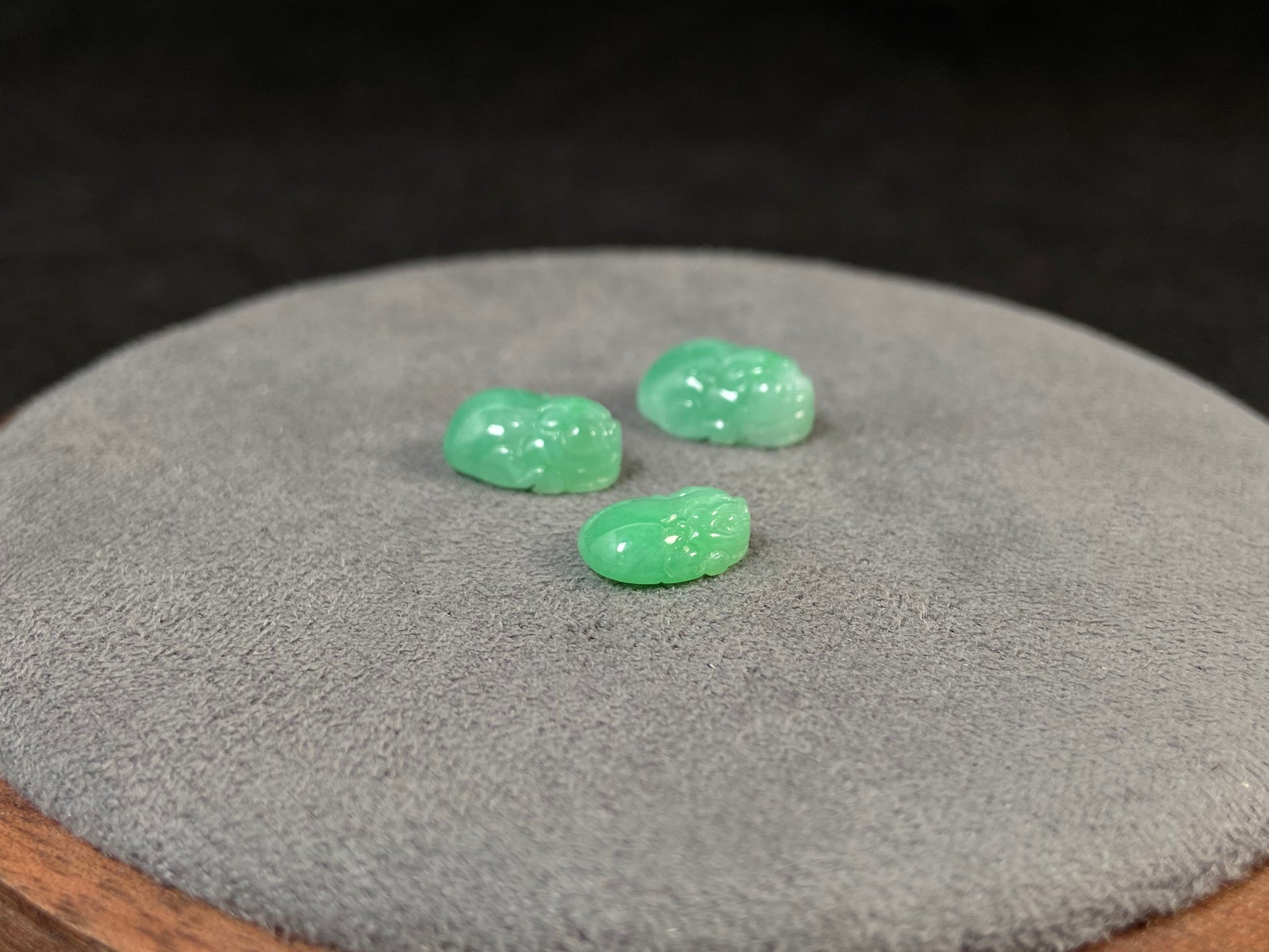 Three green Pixiu carvings of varying sizes, crafted from jade.