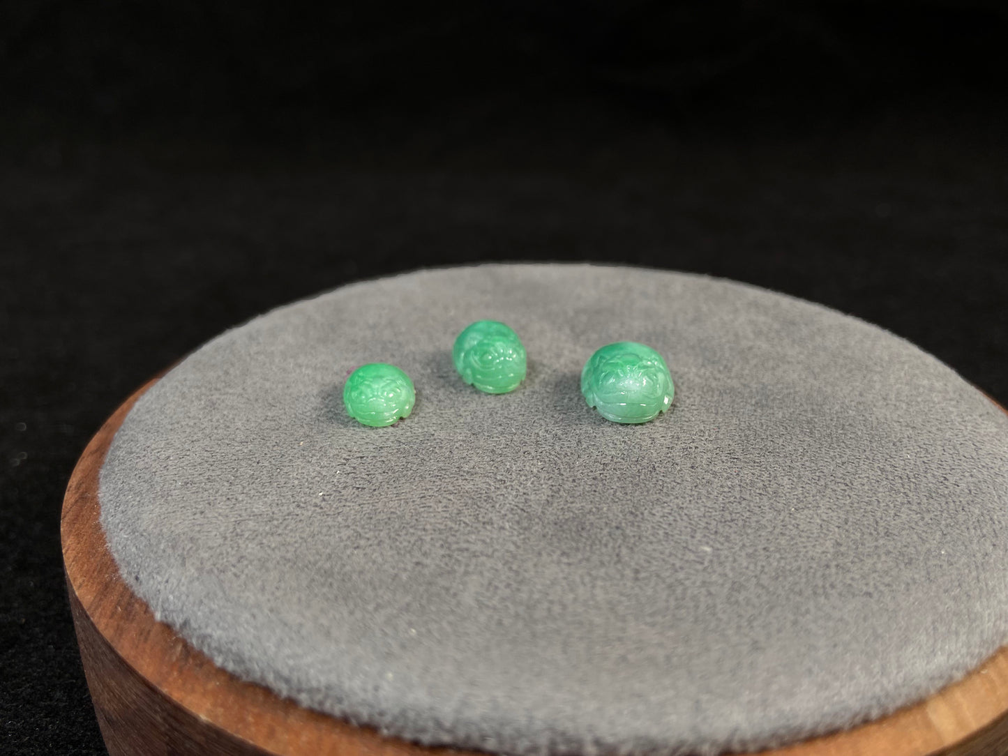 Three green Pixiu carvings of varying sizes, crafted from jade.