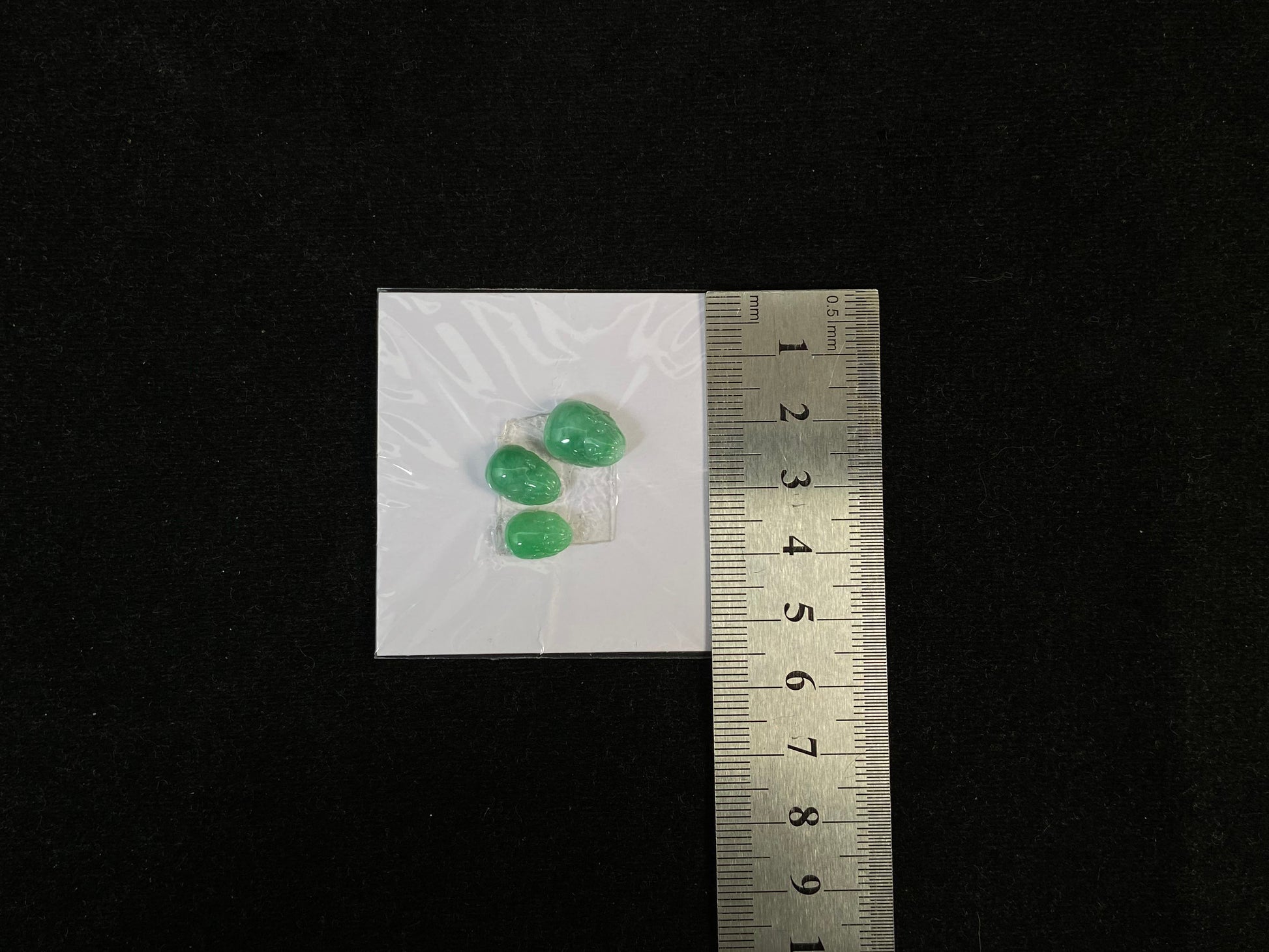 Three green Pixiu carvings of varying sizes, crafted from jade.