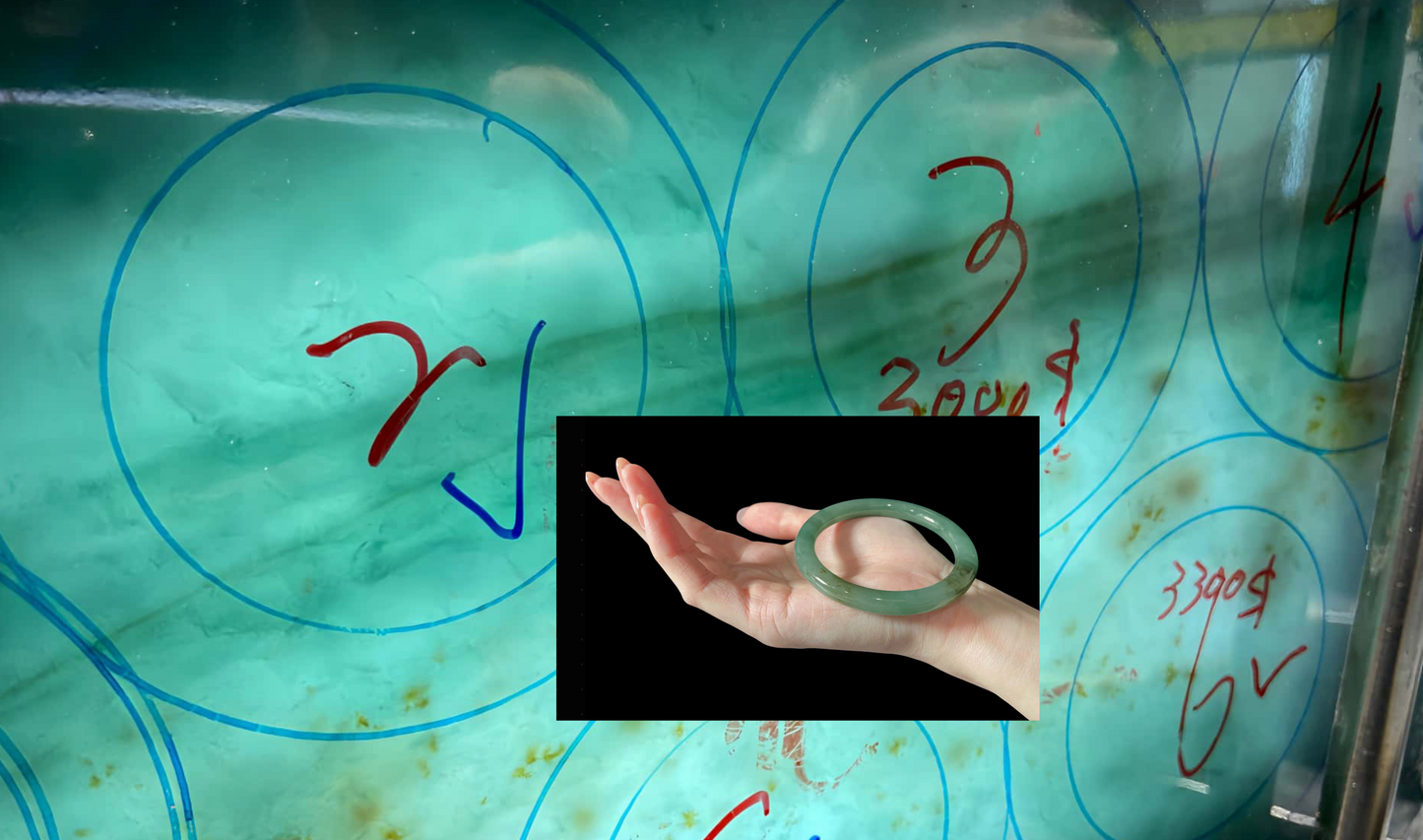 Hand holding a jade ring with a blurred background of circular patterns and measurements.  Multi-purpose Carving of Jadeite Rough Stones & Custom Bangle Services