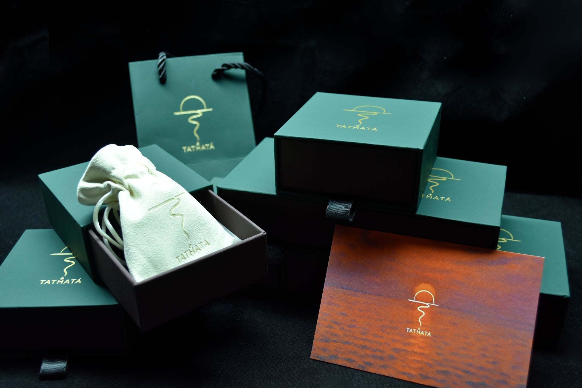 Green packaging box with a white product and branded card on a dark background