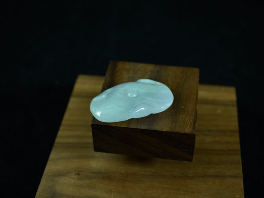 White stone on a wooden block against a dark background