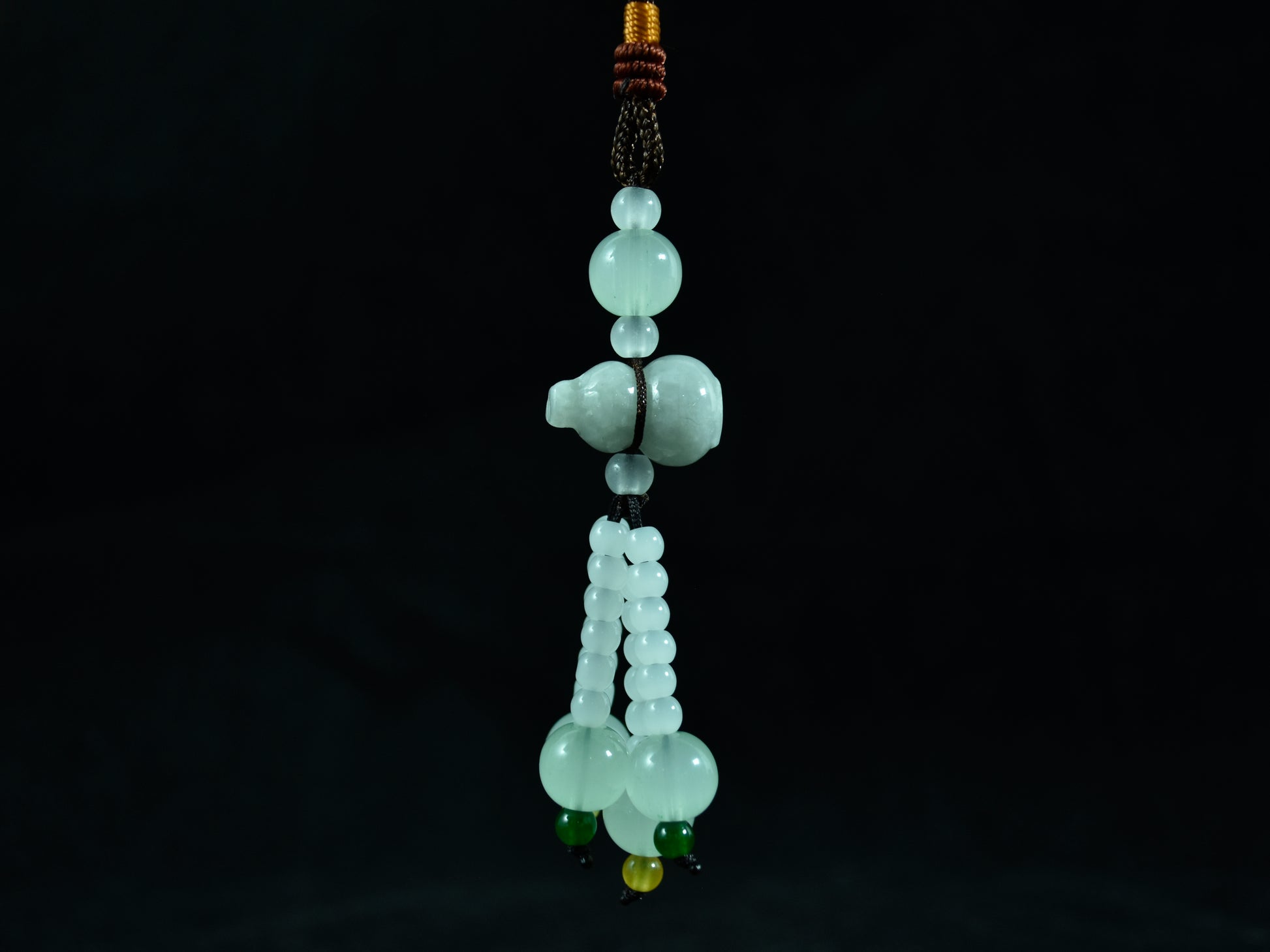 Green jade bead necklace on a black background