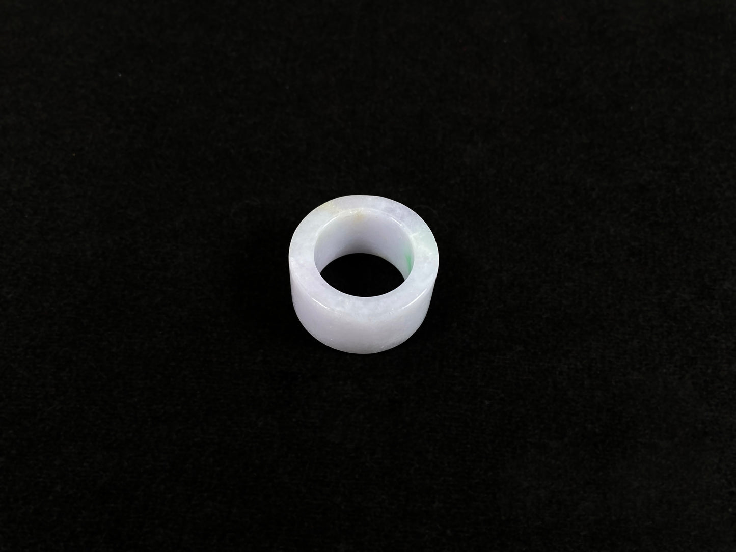 This creamy white jadeite thumb ring features elegant green veining.