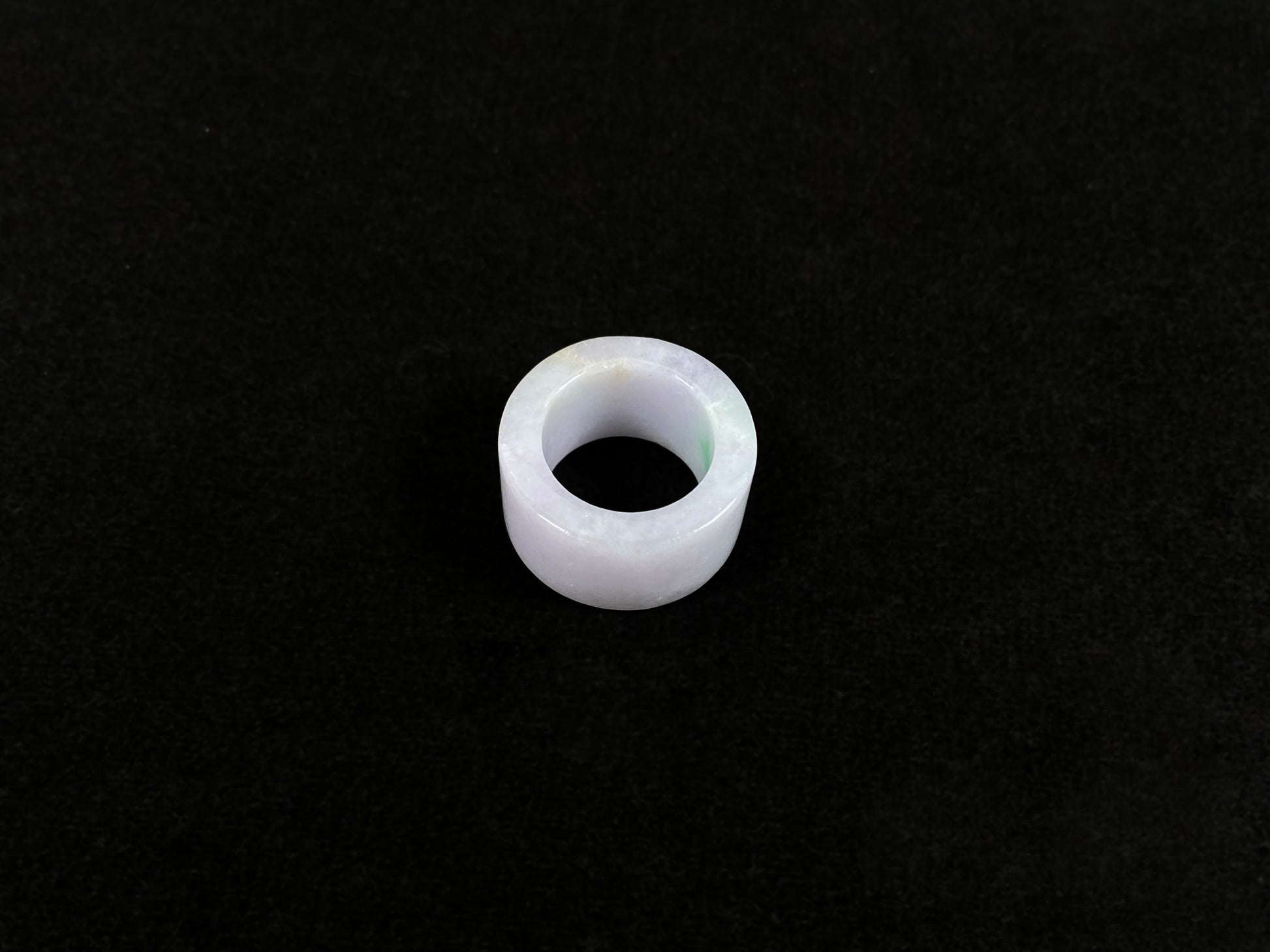 This creamy white jadeite thumb ring features elegant green veining.