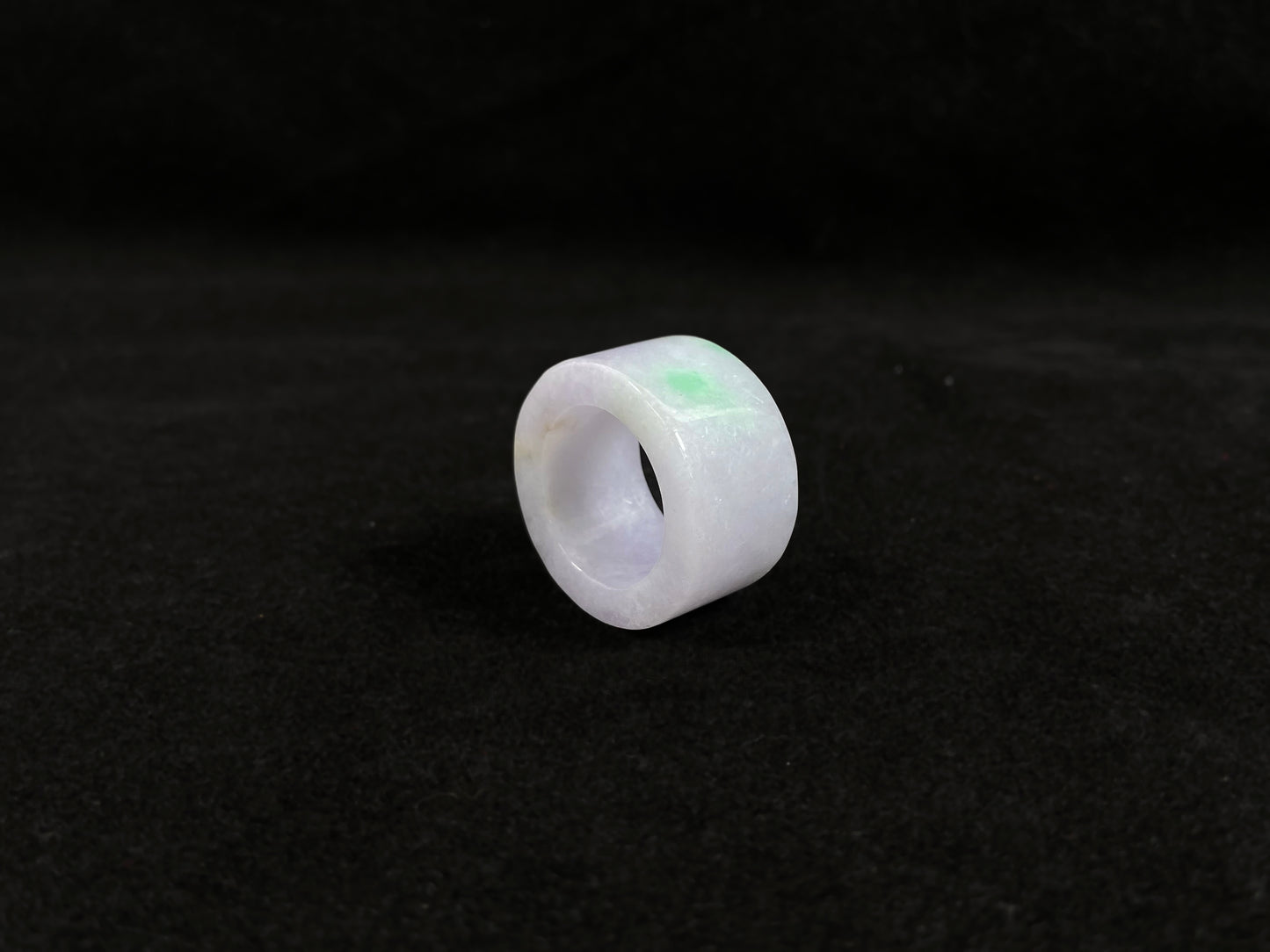 This creamy white jadeite thumb ring features elegant green veining.