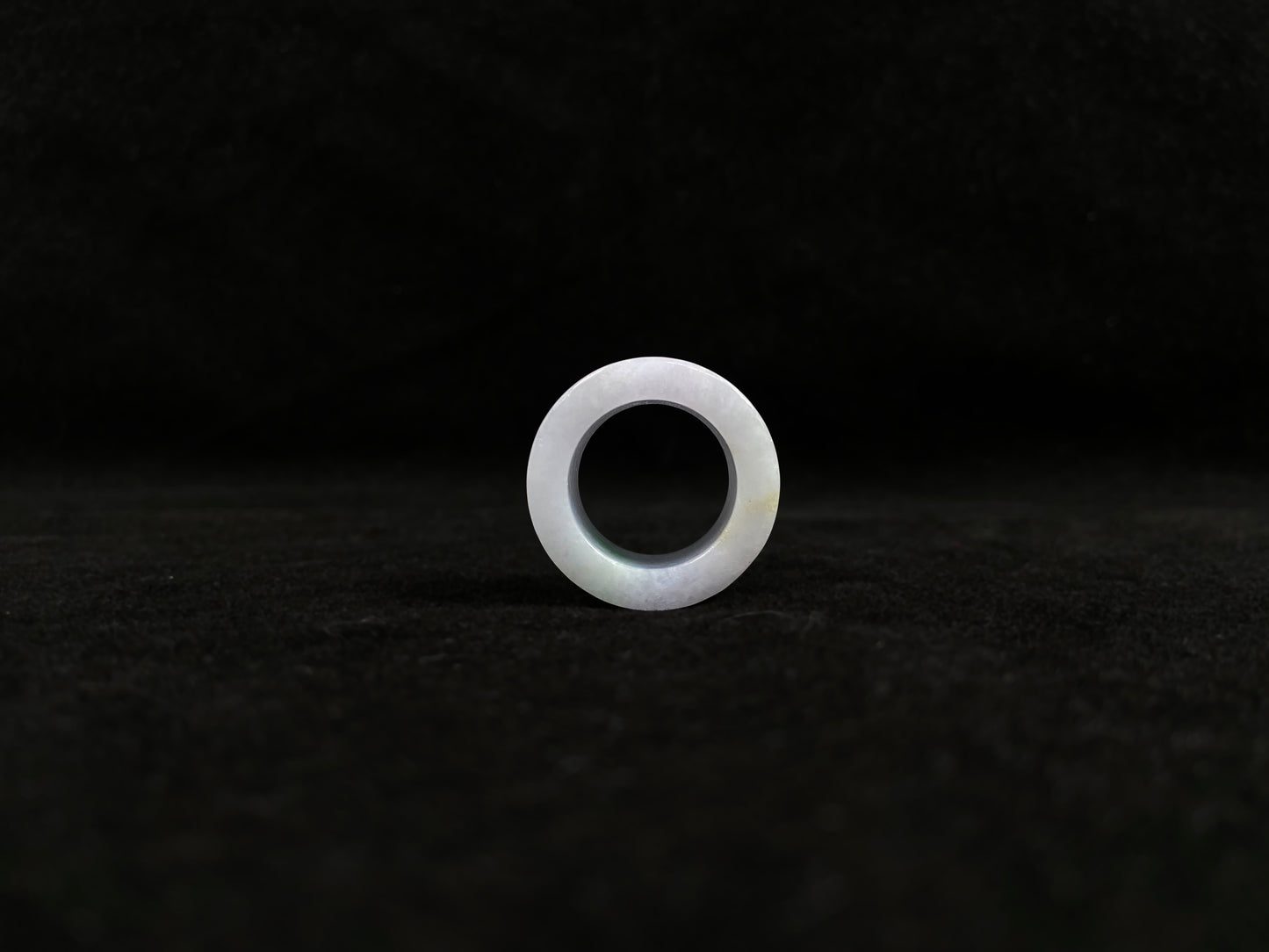 This creamy white jadeite thumb ring features elegant green veining.