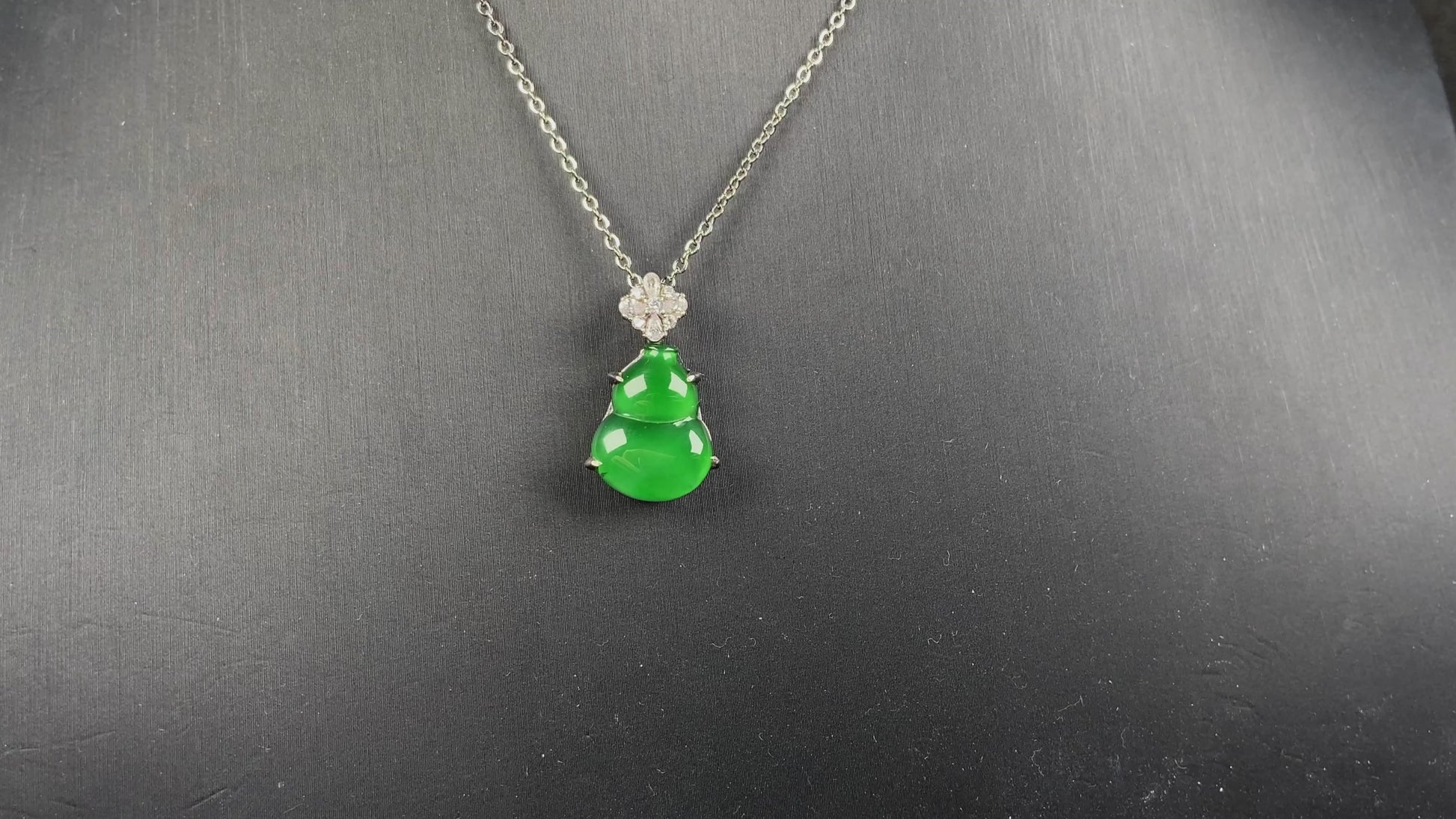 A diamond floral green hulu jadeite pendant.