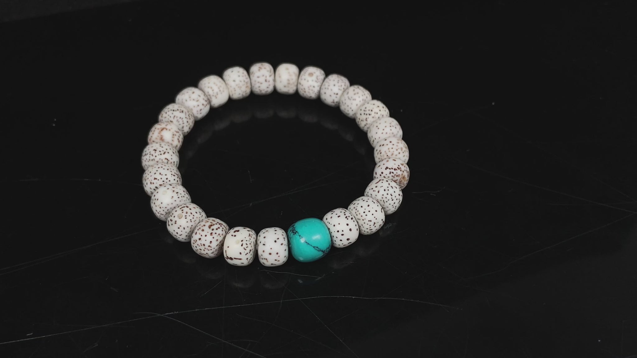 A crimson specks on cream star and moon bodhi beaded bracelet.