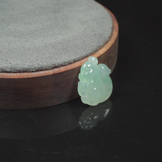 This jadeite carving features a lifelike three-dimensional squirrel rendered in a soft, luminous green with a pale white base.