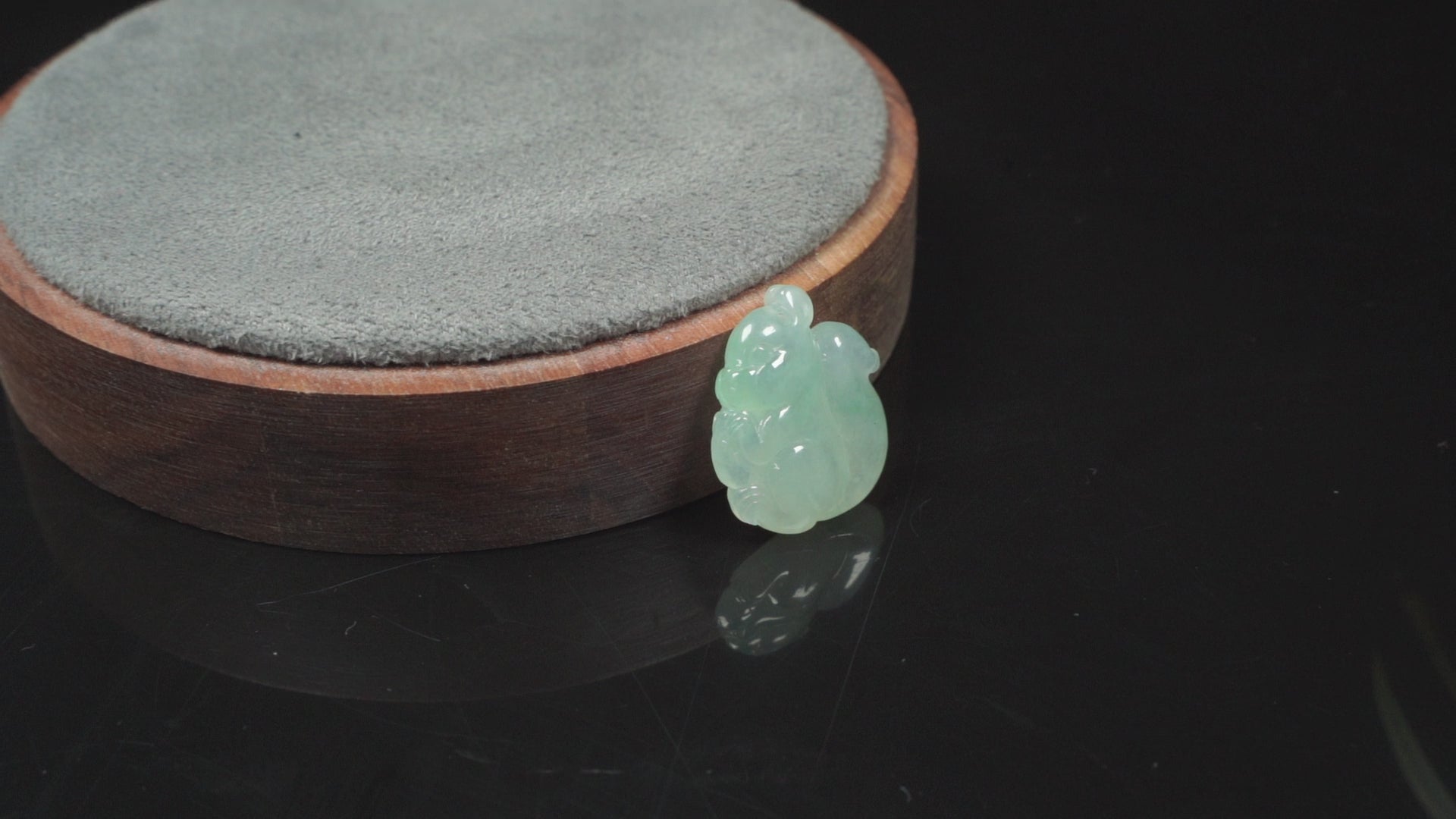 This jadeite carving features a lifelike three-dimensional squirrel rendered in a soft, luminous green with a pale white base.