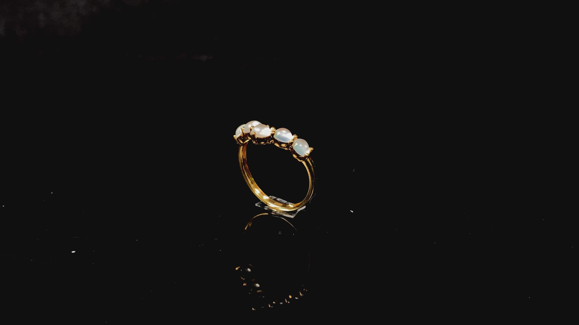 A clear bead cluster crown on gold jadeite ring.