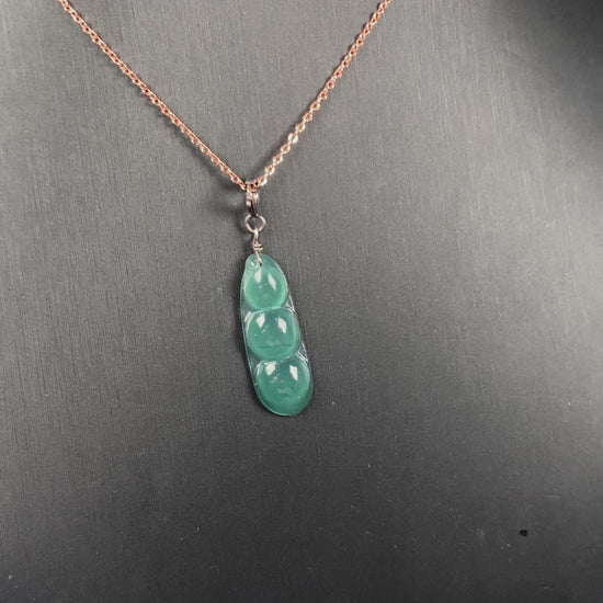 A watery blue lucky pea pod jadeite pendant.
