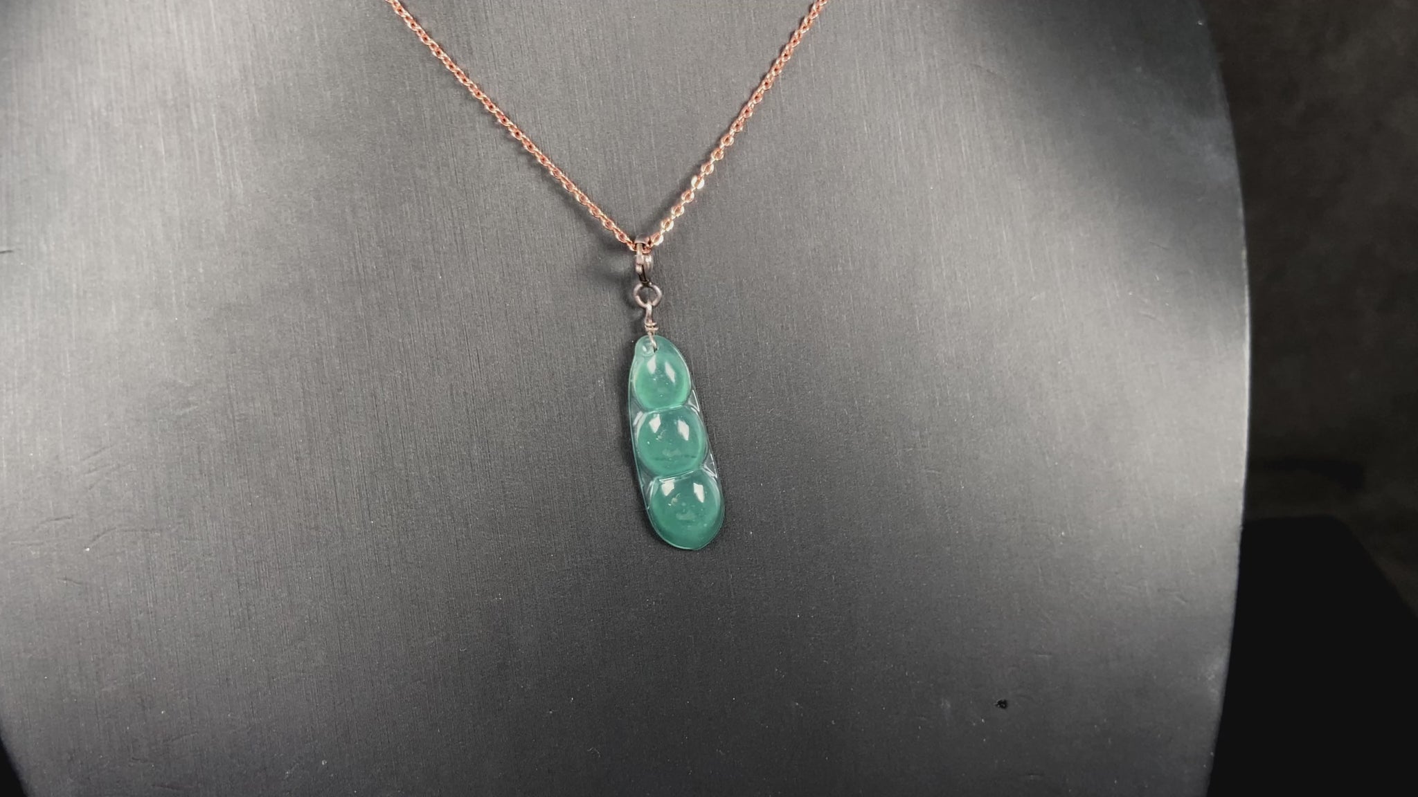 A watery blue lucky pea pod jadeite pendant.