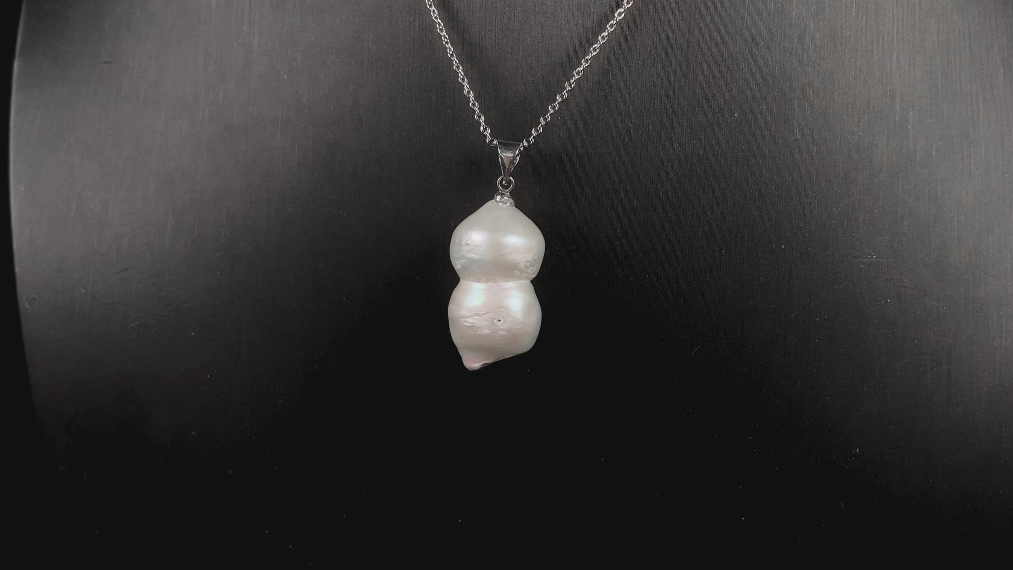 A milky white with blush overtones lucky gourd silhouette pearl pendant.