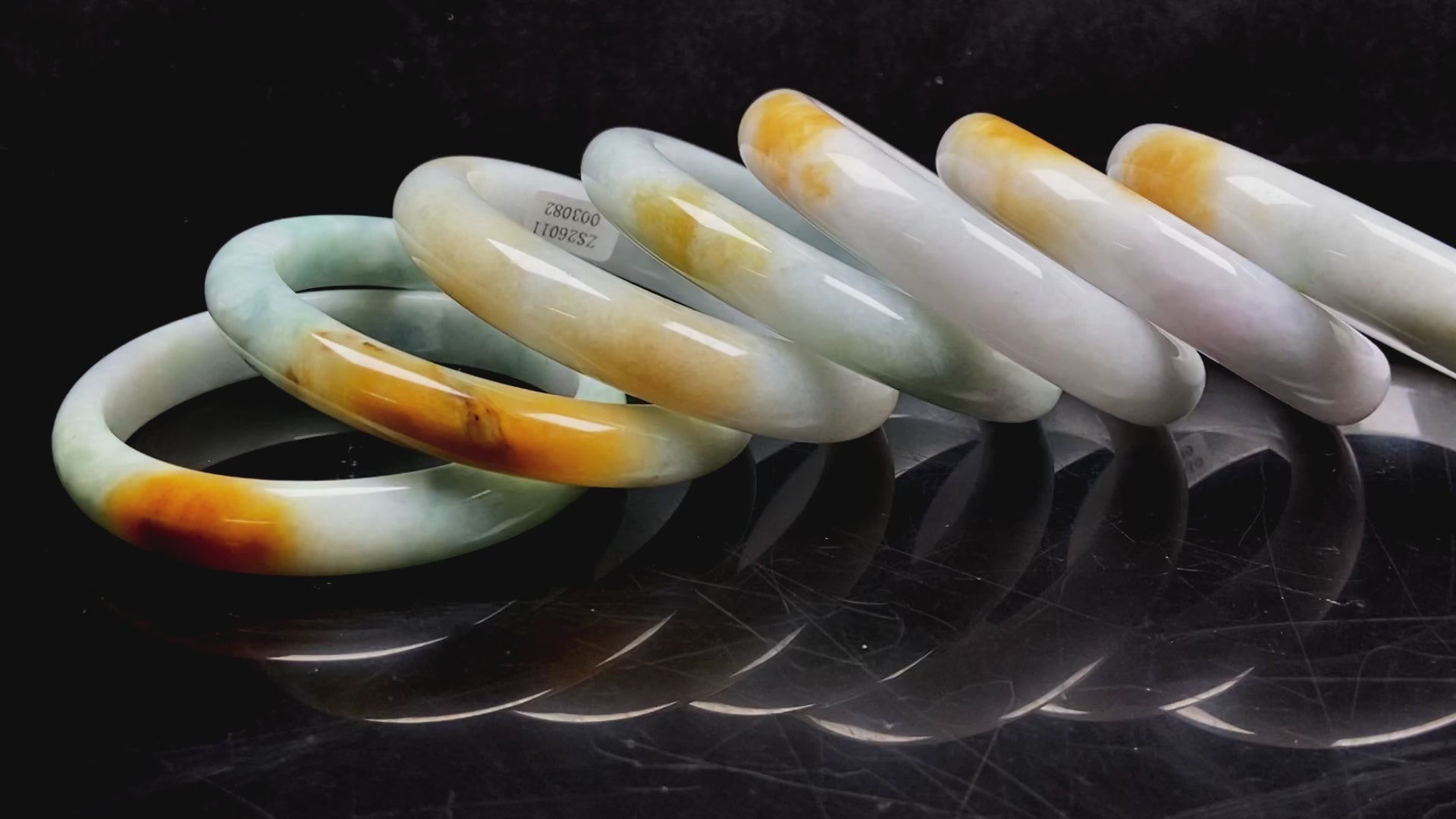 Load video: A white and gold jadeite bangle group video.
