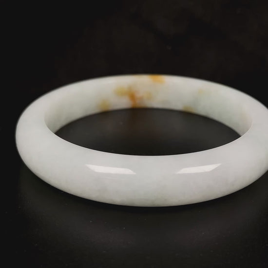 A amber touched snow jadeite bangle.