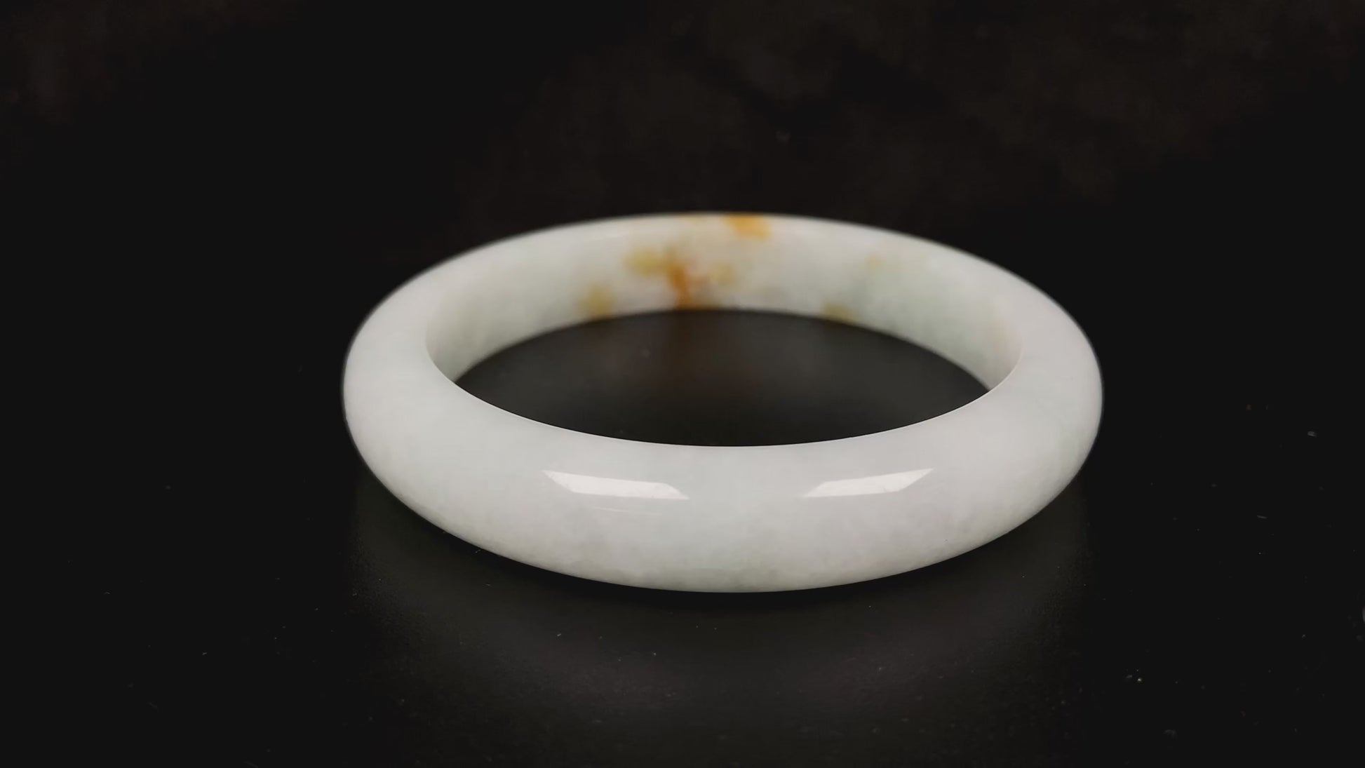 A amber touched snow jadeite bangle.
