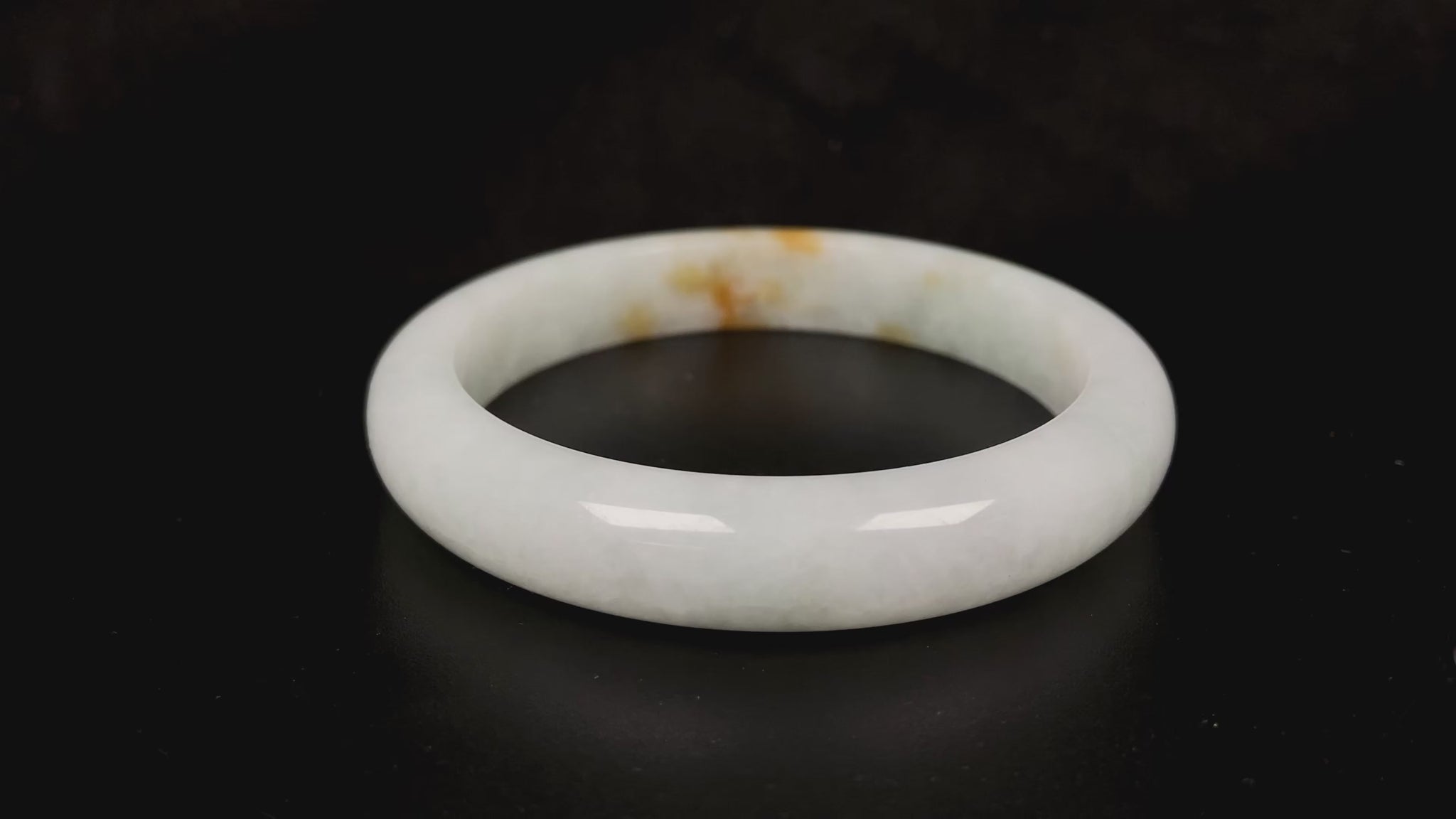A amber touched snow jadeite bangle.