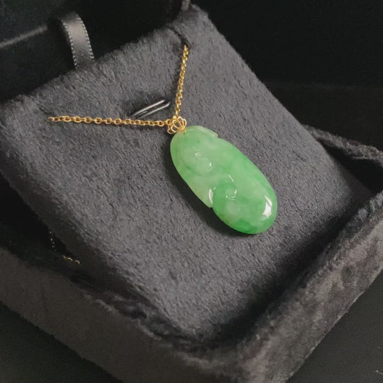A foat green Ruyi jadeite pendant.