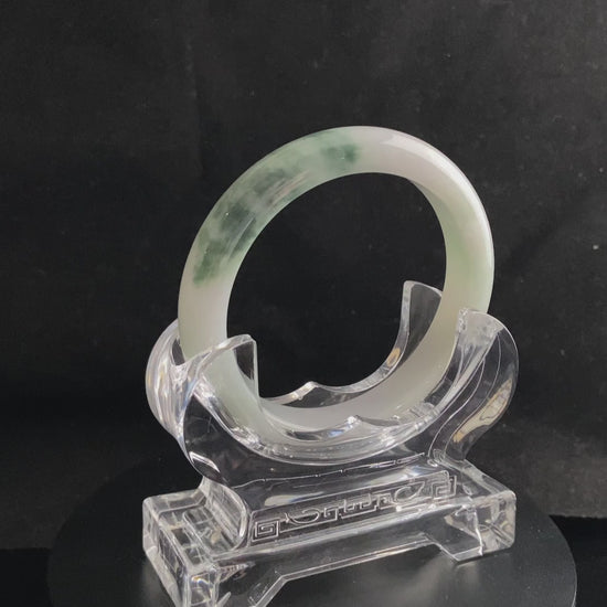 A snow white with green splash jadeite bangle.