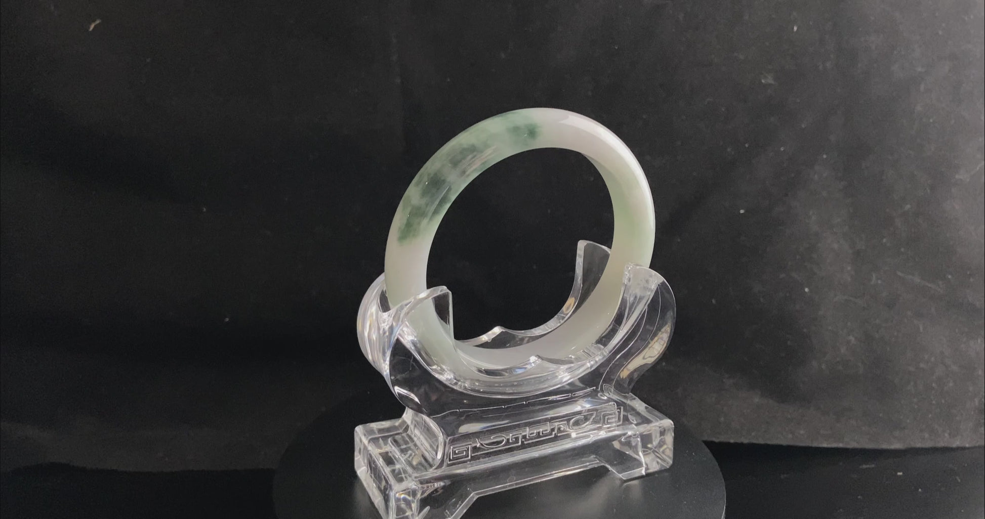 A snow white with green splash jadeite bangle.