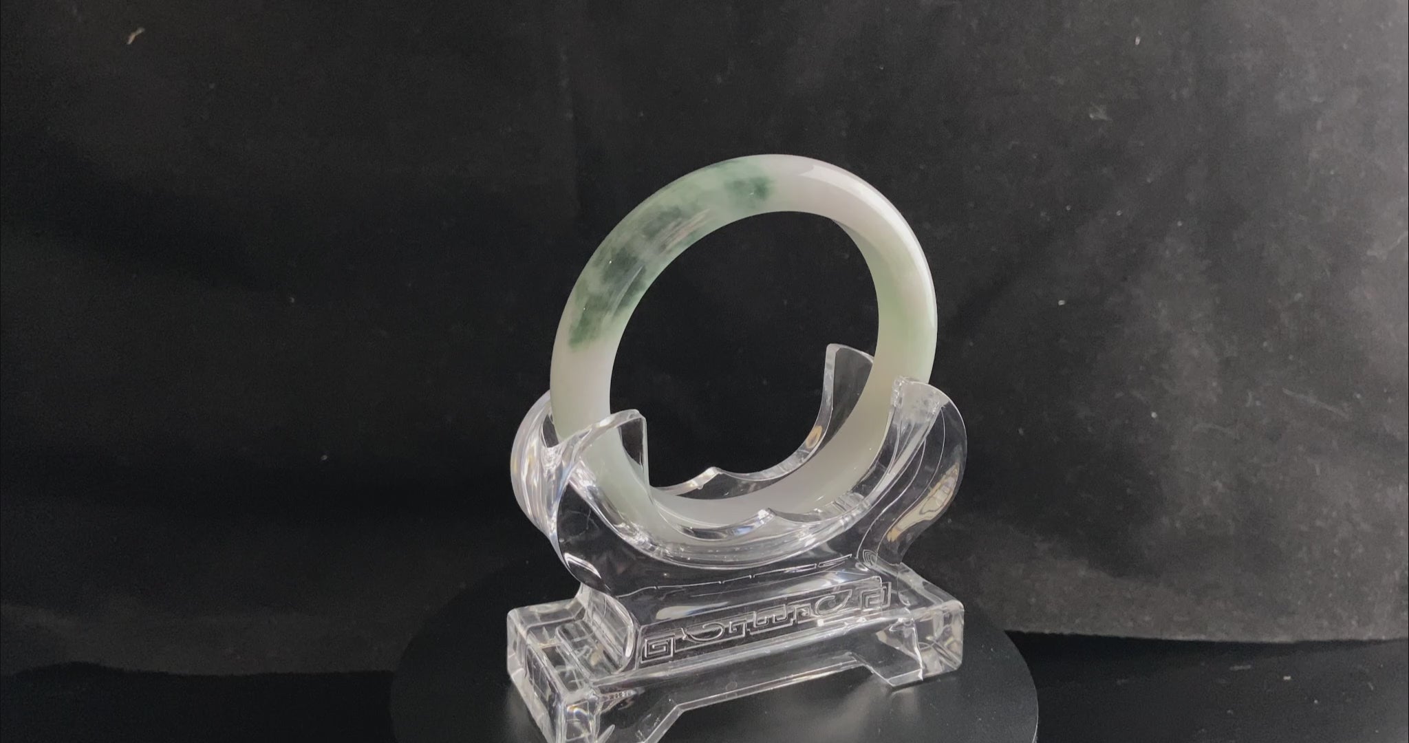 A snow white with green splash jadeite bangle.