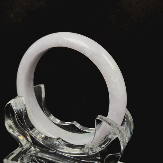 A cloudy white with pale green streaks jadeite bangle.