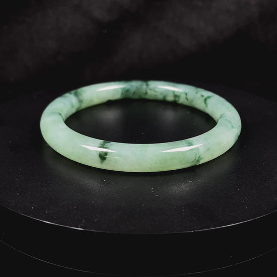 A waxy icy with moss green jadeite bangle.