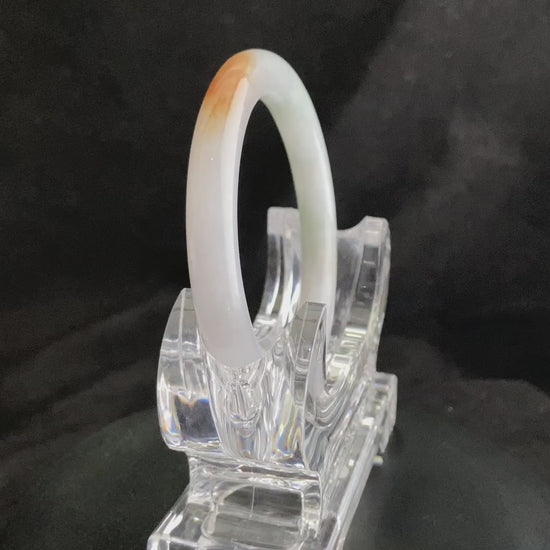 A pure white warm orange inlay jadeite bangle.
