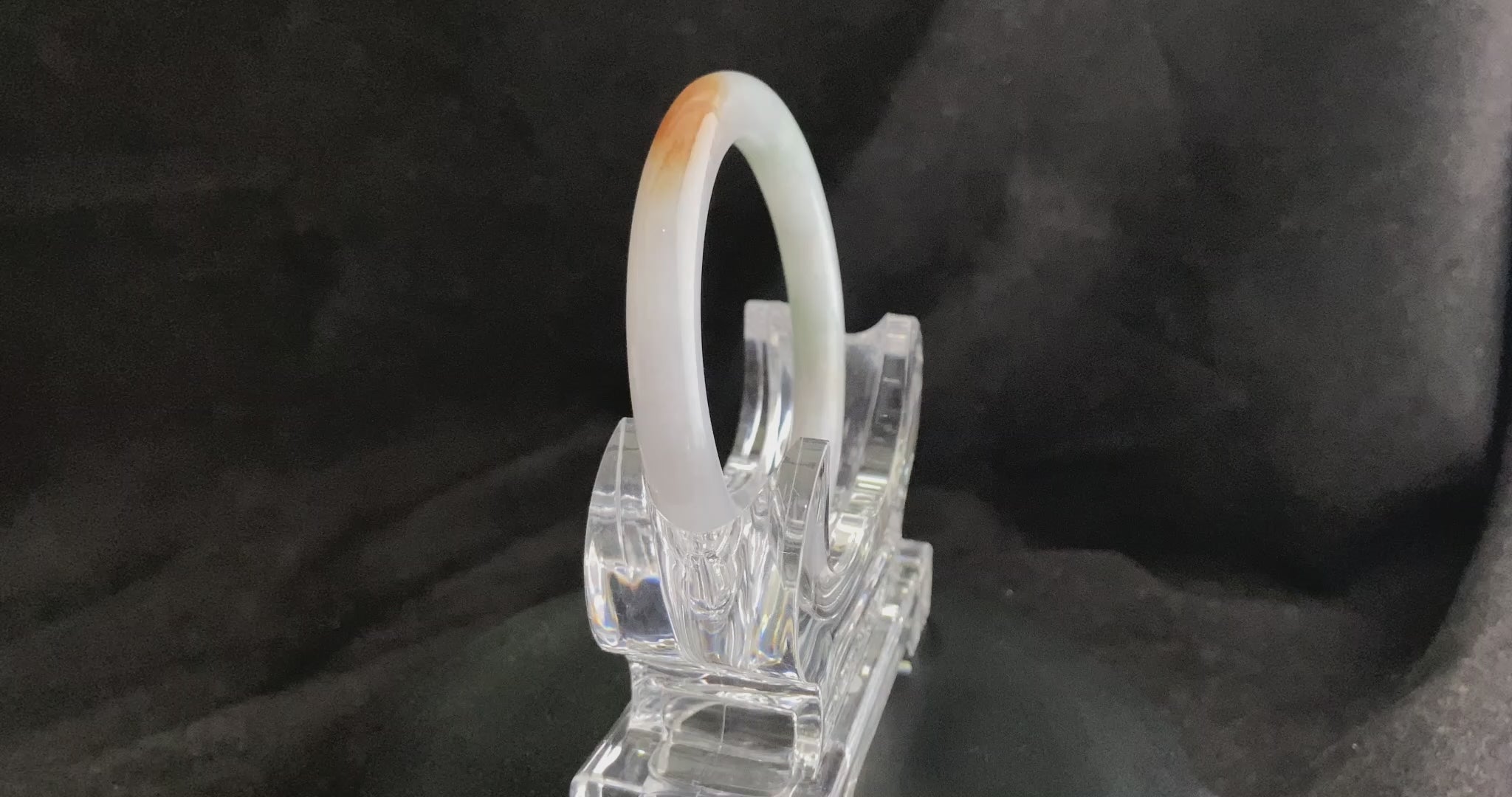 A pure white warm orange inlay jadeite bangle.