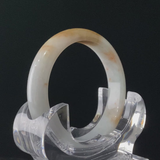 A amber dawn vein jadeite bangle.