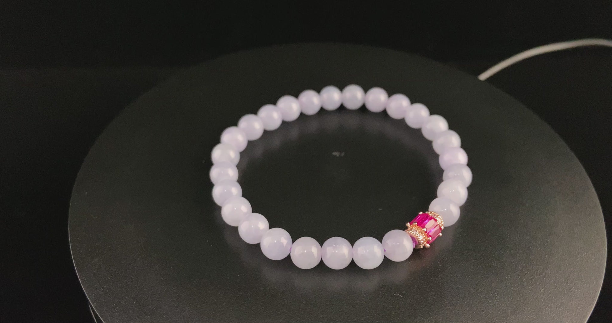 A clear white with pink thread jadeite beads bracelet.