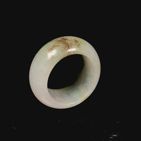 A pale verdant with golden dots jadeite ring.