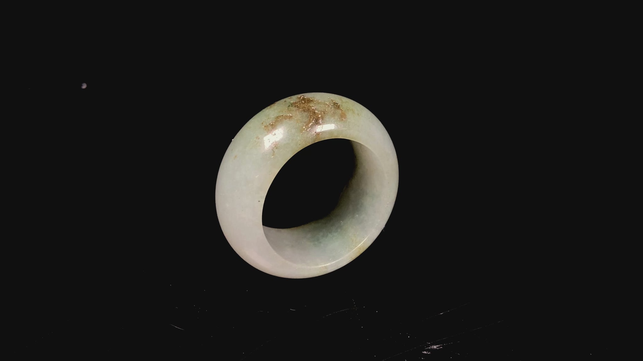 A pale verdant with golden dots jadeite ring.