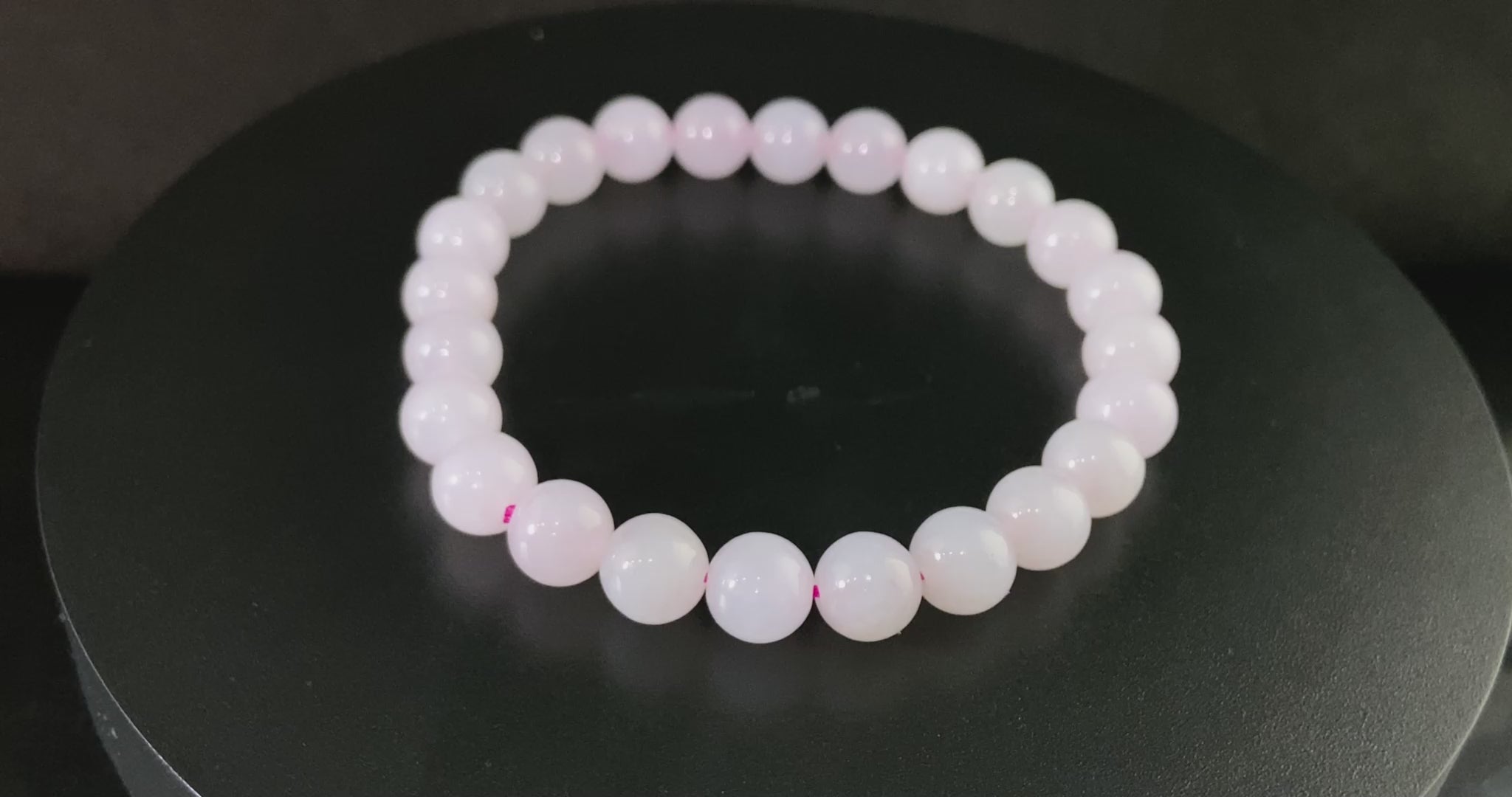 A clear white with pink thread jadeite beads bracelet.