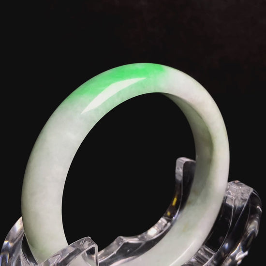 A white base with sunlit green jadeite bangle.