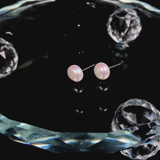 A pair of bloom pink glow pearl earrings.