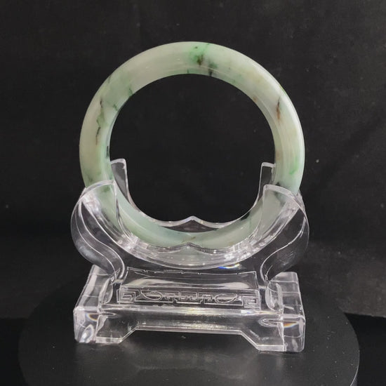 A white base with multi-colored inclusions jadeite bangle.